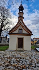 Kamienny mur i elewacja kościółka.